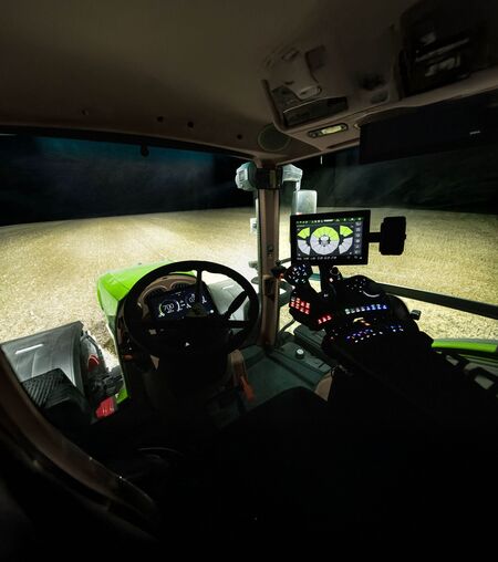 Indeni kabinen på en Fendt 800 Vario med høj belysning udenfor i mørket